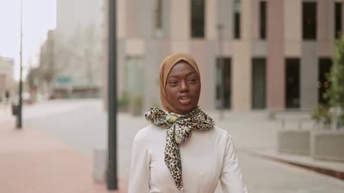 Stilvolle muslimische Frau geht auf Bürgersteig