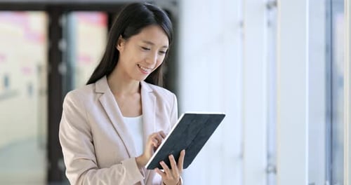 Woman Using Tablet Device in Modern Office