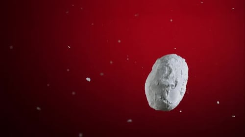 White Object Falling Against Red Background
