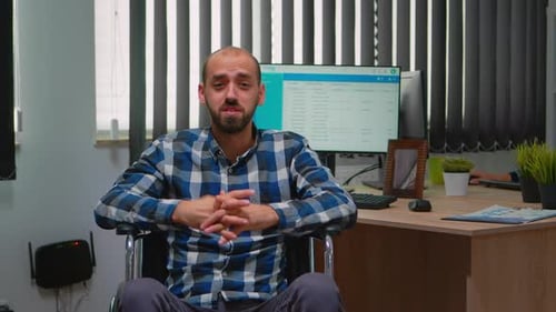 Adult in Wheelchair Talking to Camera in Office