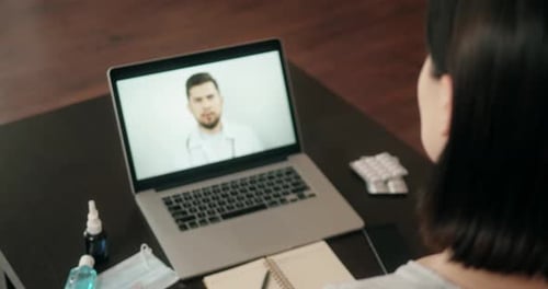 Back View of Woman Making Video Call with Her Doctor While Staying at Home During Coronavirus