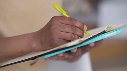 Side View of Male African American Hand Writing with Pen in Sketchpad