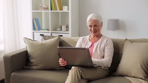 Senior Woman Using Laptop Computer on Couch