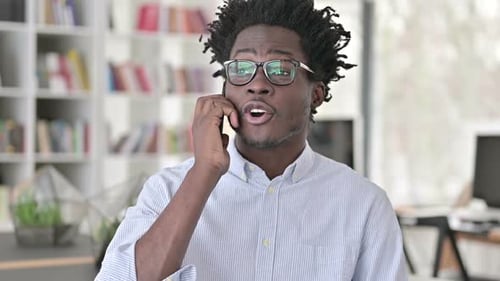 Young Adult Talking on Phone in Home Office