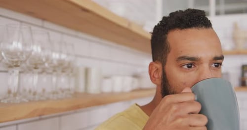 Man Drinks from Mug Indoors Close Up