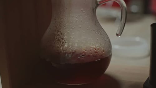 Pouring Dark Drink Into Clear Glass Pitcher