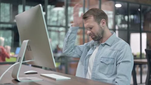 Kreativer junger Mann reagiert auf Verlust bei der Arbeit