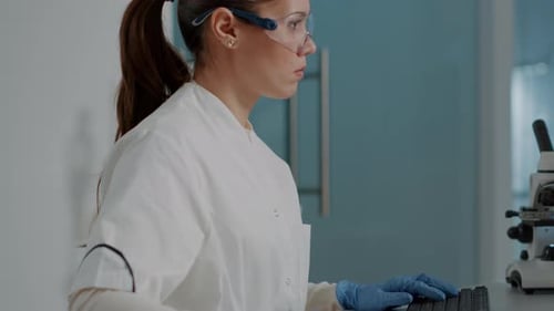 Woman Working in Lab Typing on Computer