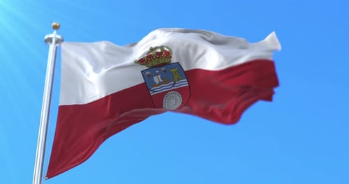Waving Flag with Coat of Arms Against Blue Sky