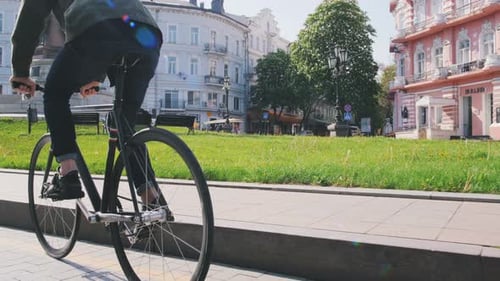 Cyclist Man Riding Fixed Gear Sport Bike in Sunny Day on a City