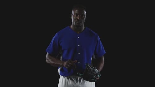 Man in Baseball Uniform Holding Ball and Glove