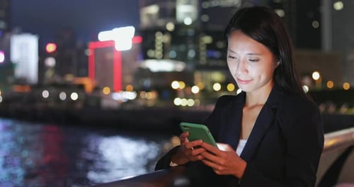 Woman Using Mobile Phone at Night in City