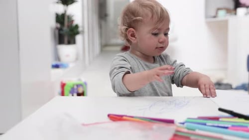 Blonde Toddler Drawing at a White Table