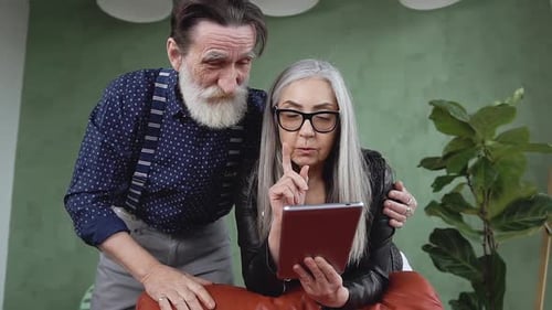 Senior Couple Using Tablet Together Indoors