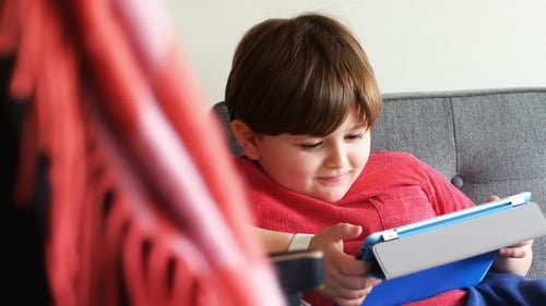 Boy on Couch Using Tablet Device