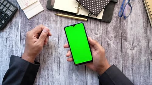 Top View of Man Hand Using Smart Phone on Office Desk