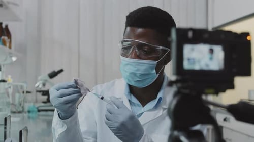 Young Adult Scientist Injecting Lab Rodent On Camera