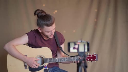 Man Plays Guitar and Records Video at Home