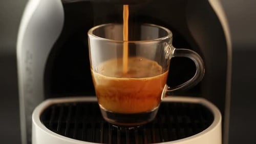 Espresso Pouring into Glass Mug from Machine