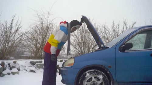 Winter, Falling Snow. Man on the Road Have Troubles with His Car. He Is Trying To Find Problem with