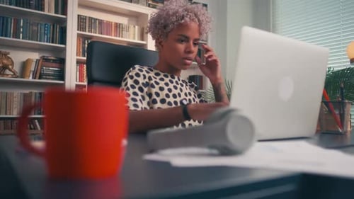 Young African American Business Woman Works with Laptop Sits at Table in Office