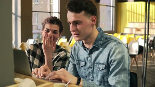 Couple Enjoying Laptop in Coffee Shop