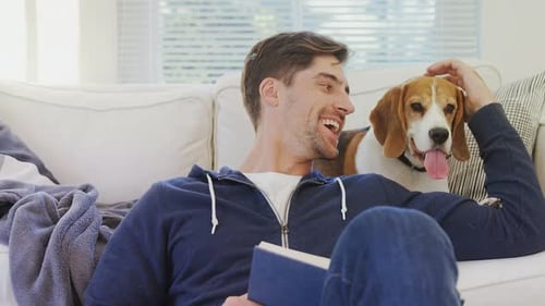 Man Reading with Dog on Couch