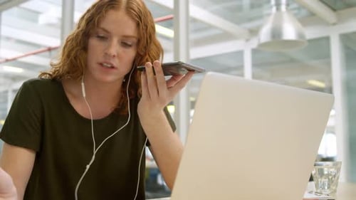 Woman Working with Laptop and Phone in Office