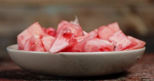 Plate with Slices of Fresh Watermelon Rotates Slowly.