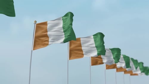 Côte d'Ivoire National Flags Waving Against Blue Sky