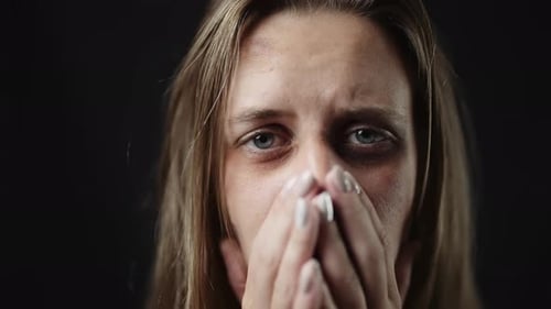 A Sad Beaten Up Woman with Tear in Eye and Bruises is Crying
