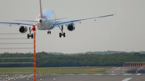 Commercial Airplane Landing on Airport Runway During Day