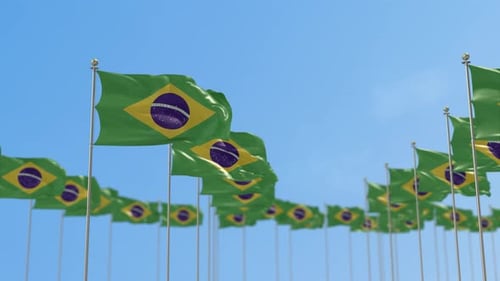 Waving Brazilian Flags on Poles Against Clear Blue Sky