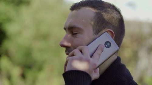 Young Adult Man Talking on Smartphone Outside