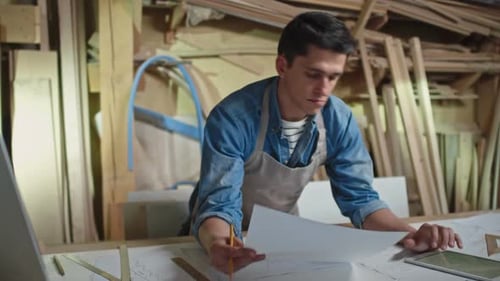 Architect Reviewing Plans with iPad in Workshop