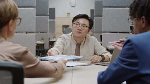 Diverse Business Team Discussing Data in Modern Office