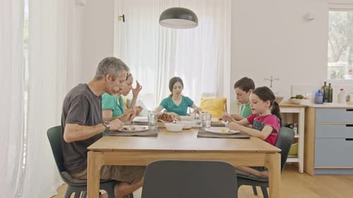 Family Enjoys Meal Together at Dining Room Table