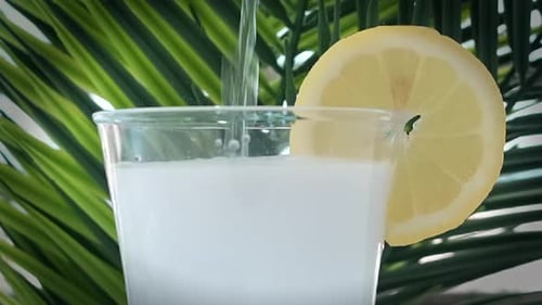 Refreshing Drink Poured Over Ice with Lemon Slice