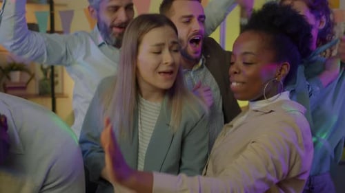 Retrato em câmera lenta de uma equipe de negócios diversificada dançando em um escritório decorado à noite