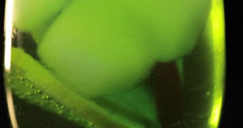 Making a Refreshing Green Drink Cocktail in a Glass with Ice, and Lime
