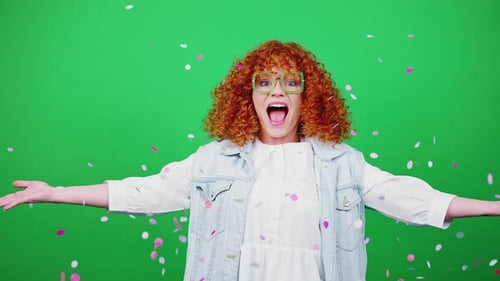 Young Happy Redhead Curly Woman Jumping and Throwing Confetti Dancing Over Green Chroma Key