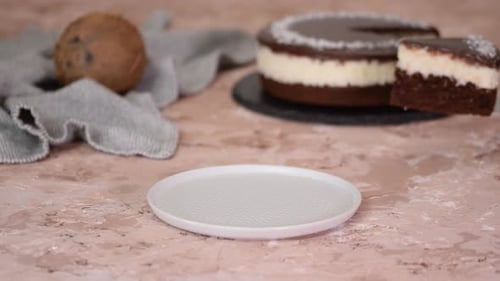 Coconut Chocolate Cake Slice Being Placed on Plate