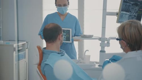 Dentist Reviews X-Rays with Patient