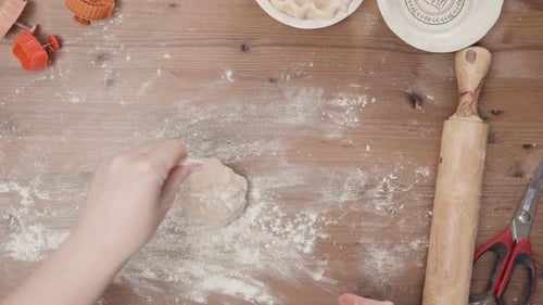 Hands Baking Pie Crust with Rolling Pin Overhead