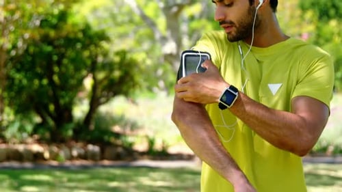 Man Adjusting Phone For Workout in Park