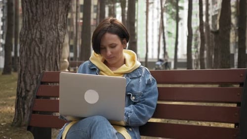 Working remotely in park with laptop