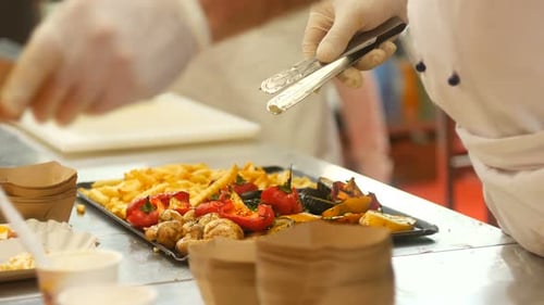 Chef Plating Cooked Vegetables and Fries