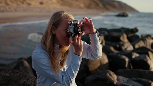Fotógrafo feminino com foco na câmera Slr