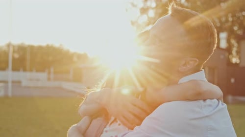 Loving Father and Daughter Embrace at Sunset