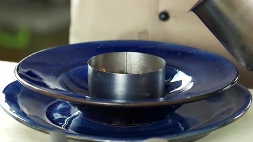 Chef Prepares Food with Metal Ring on Plate